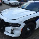 A police car that has been damaged by the side of it.