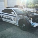 A police car that has been smashed and broken.