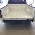 A truck bed with the floor in place.